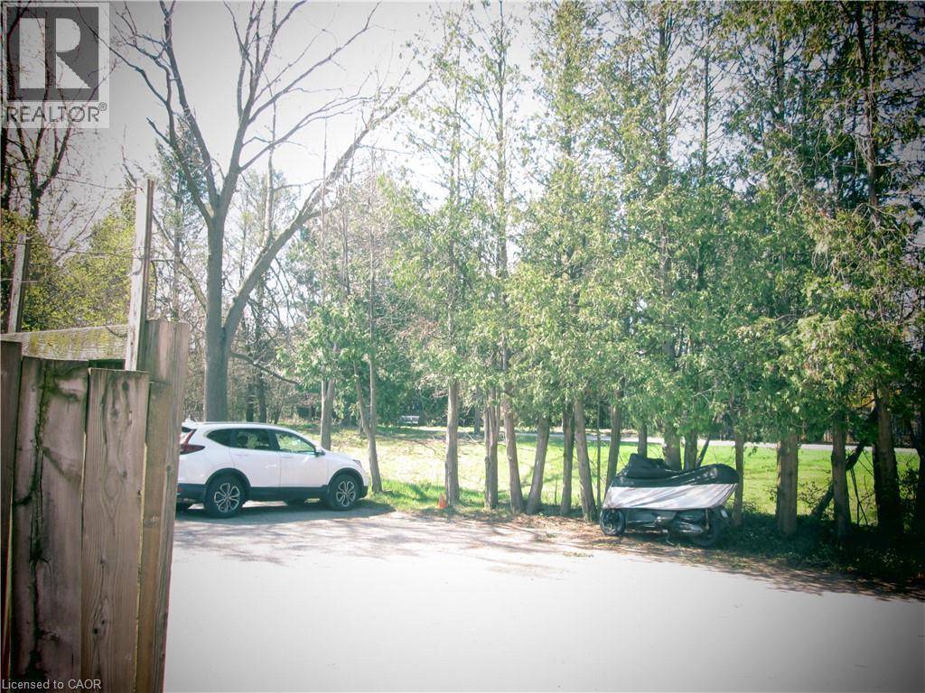 Gravel driveway with mature trees and a wood fence - 648 Francis Road, Burlington, ON - Outdoor