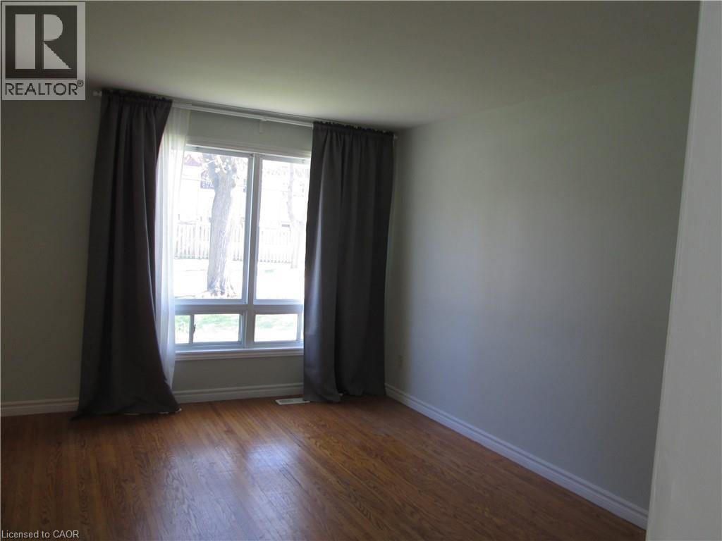 Hardwood-finish flooring, neutral wall tones, and white trim highlight this room - 648 Francis Road, Burlington, ON - Indoor Photo Showing Other Room