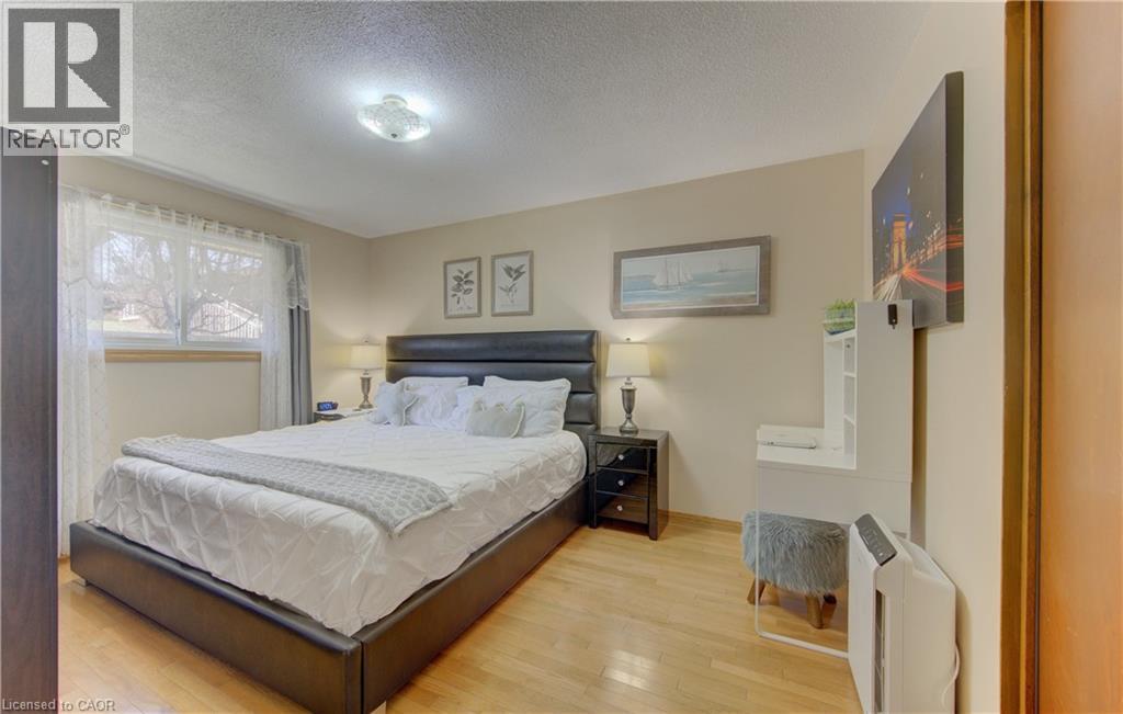 Bedroom featuring wood-finish flooring, a double window with light-filtering privacy sheers, and crown molding - 170 Martinglen Crescent, Kitchener, ON - Indoor Photo Showing Bedroom