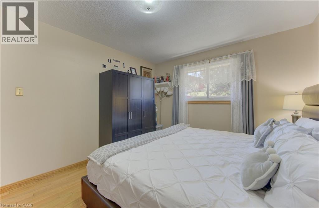 Light-toned walls with wood-finish flooring - 170 Martinglen Crescent, Kitchener, ON - Indoor Photo Showing Bedroom