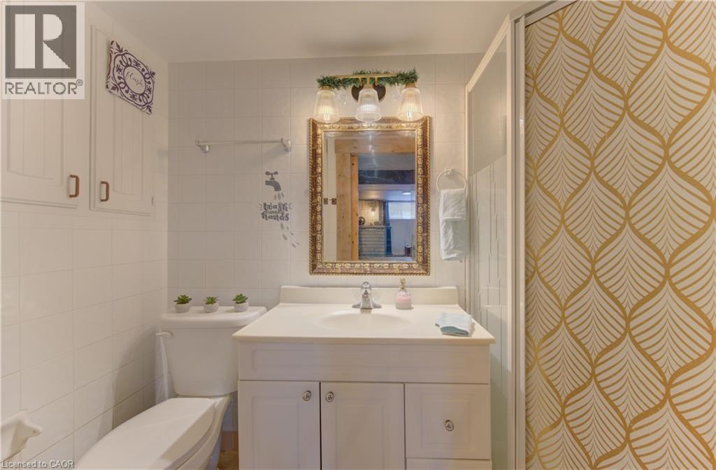 Bathroom vanity with a single basin sink, white cabinetry, and a framed mirror - 170 Martinglen Crescent, Kitchener, ON - Indoor Photo Showing Bathroom
