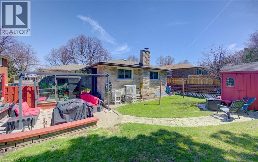 Expansive backyard featuring a stone patio, manicured lawn, and paved walkway - 170 Martinglen Crescent, Kitchener, ON - Outdoor With Deck Patio Veranda