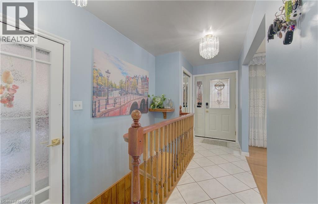 Entryway featuring ceramic tile flooring, a decorative front door with leaded glass, and a crystal drop light fixture - 170 Martinglen Crescent, Kitchener, ON - Indoor Photo Showing Other Room