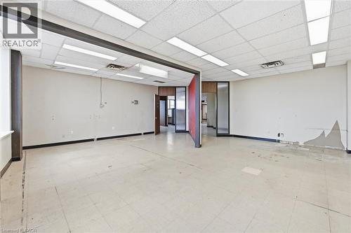 Spacious interior featuring a dropped acoustic ceiling, integrated fluorescent lighting, and a neutral-toned tile floor - 869 Barton Street E, Hamilton, ON 