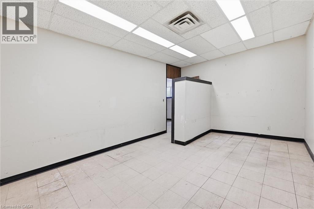 Open space with neutral walls, white ceiling tiles, and recessed lighting - 869 Barton Street E, Hamilton, ON