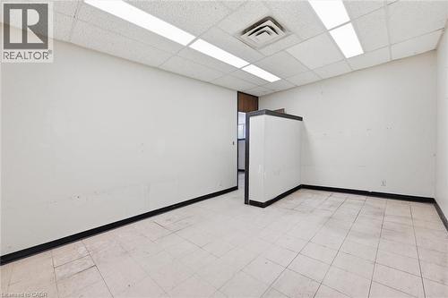 Open space with neutral walls, white ceiling tiles, and recessed lighting - 869 Barton Street E, Hamilton, ON 