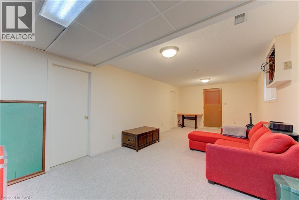 Carpeted interior space featuring light-toned walls and a grid-patterned drop ceiling - 98 Shea Crescent, Kitchener, ON - Indoor