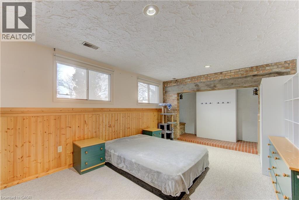 Carpeted room featuring wood paneling, recessed lighting, and two windows - 98 Shea Crescent, Kitchener, ON - Indoor Photo Showing Bedroom