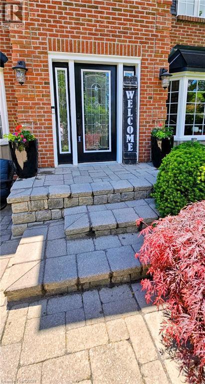 Brick facade featuring a black front door with decorative glass, two sidelights, and exterior sconces - 2324 Homer Drive, Burlington, ON - Indoor Photo Showing Other Room
