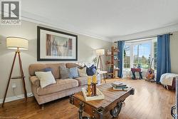 Bay window with multiple panes, crown molding, wood-finish flooring, and light wall tones -