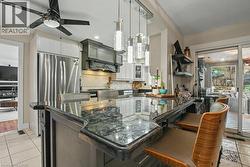 Kitchen island with a dark granite countertop and integrated seating -