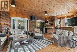 Expansive enclosed patio featuring a wood-finish ceiling, brick walls, bay window with stained glass detail, and wood-finish flooring -