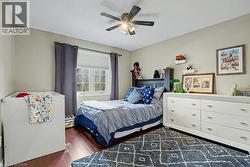 Hardwood-finish flooring, a multi-pane window with blinds, and a ceiling fan with integrated lighting -
