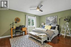 Spacious room featuring wood-finish flooring, a ceiling fan with integrated lighting, and a double window with white trim -