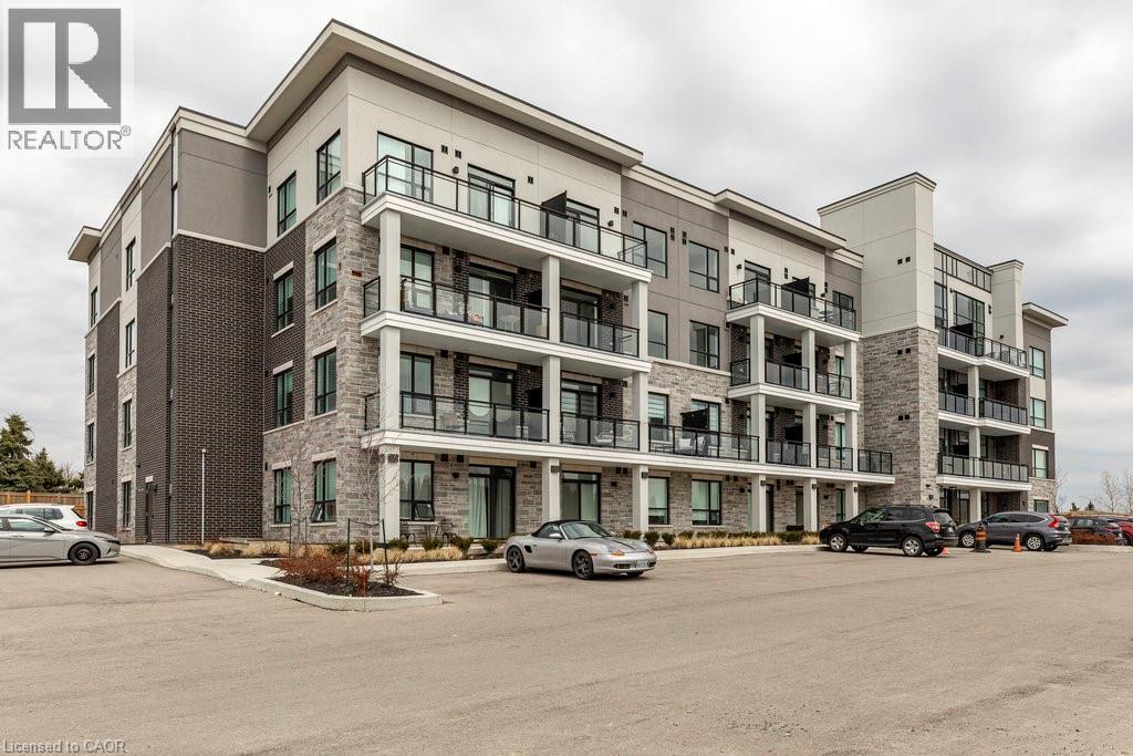 Contemporary multi-story building featuring a blend of dark brick, light stone veneer, and light-toned siding - 120 Springvalley Crescent Unit# 208, Hamilton, ON - Outdoor With Balcony With Facade
