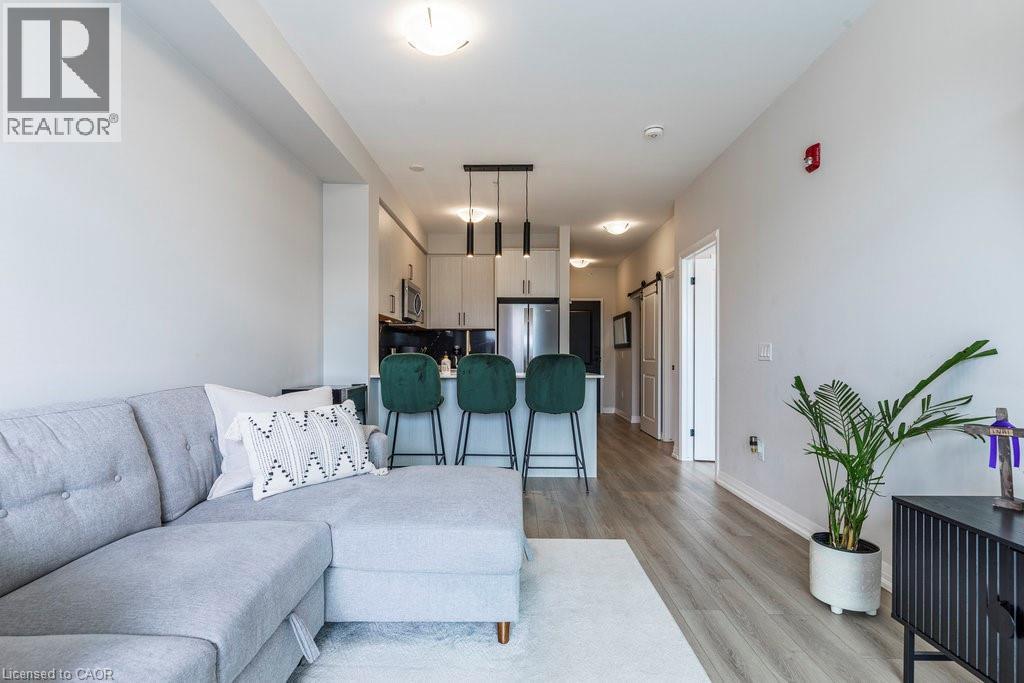 Open-concept living area featuring light wood-finish flooring - 120 Springvalley Crescent Unit# 208, Hamilton, ON - Indoor Photo Showing Living Room