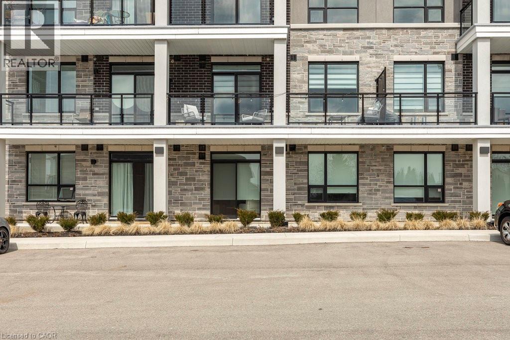 Contemporary multi-story building featuring stone veneer and dark brick facade accents - 120 Springvalley Crescent Unit# 208, Hamilton, ON - Outdoor With Balcony With Facade