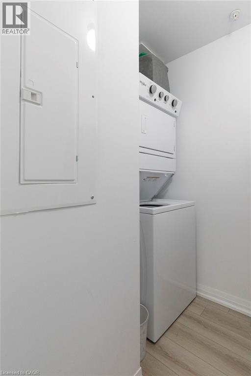 Dedicated laundry area featuring a stacked washer and dryer unit - 120 Springvalley Crescent Unit# 208, Hamilton, ON - Indoor Photo Showing Laundry Room