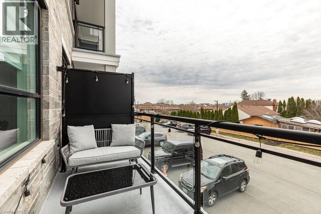Private balcony with a glass and black metal railing - 120 Springvalley Crescent Unit# 208, Hamilton, ON - Outdoor With Balcony With Exterior