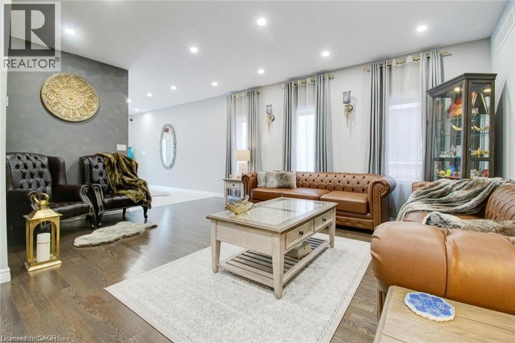 Living room with an accent wall, wood finished floors, and recessed lighting - 49 Scots Pine Trail, Kitchener, ON - Indoor Photo Showing Living Room