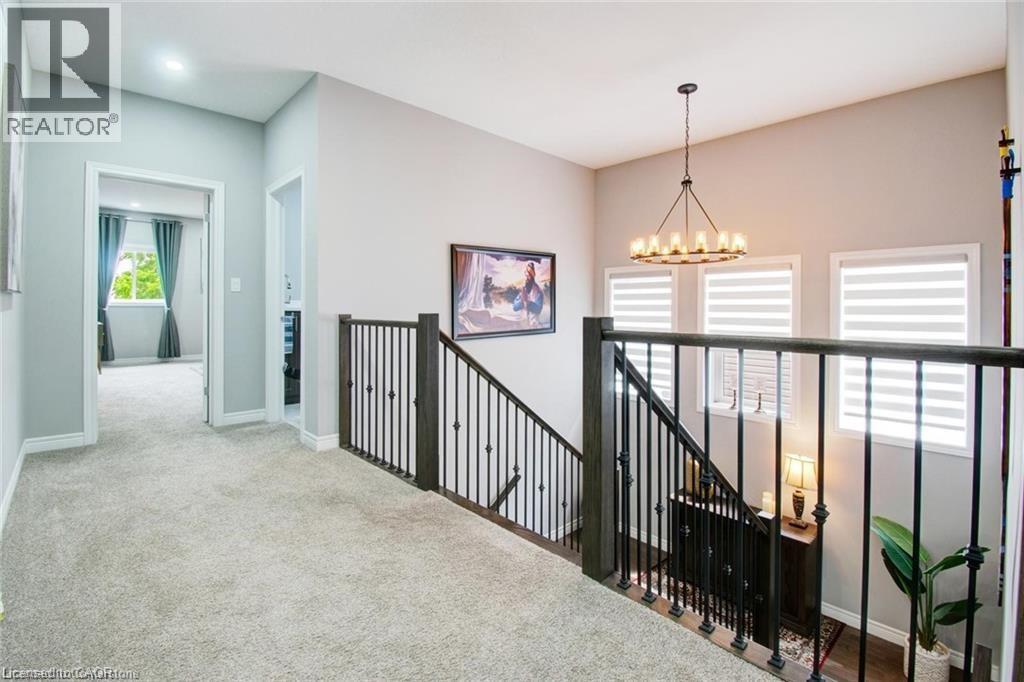 Hall with an upstairs landing, cozy carpet flooring, and a round chandelier - 49 Scots Pine Trail, Kitchener, ON - Indoor Photo Showing Other Room