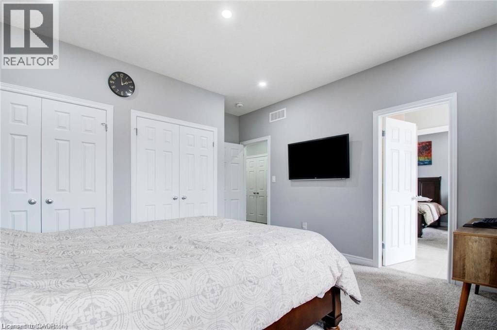 Bedroom featuring light colored carpet, multiple closets, and recessed lighting - 49 Scots Pine Trail, Kitchener, ON - Indoor Photo Showing Bedroom