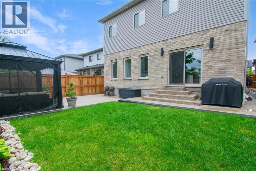 Back of property with a patio area, a gazebo, a fenced backyard, and brick siding - 49 Scots Pine Trail, Kitchener, ON - Outdoor