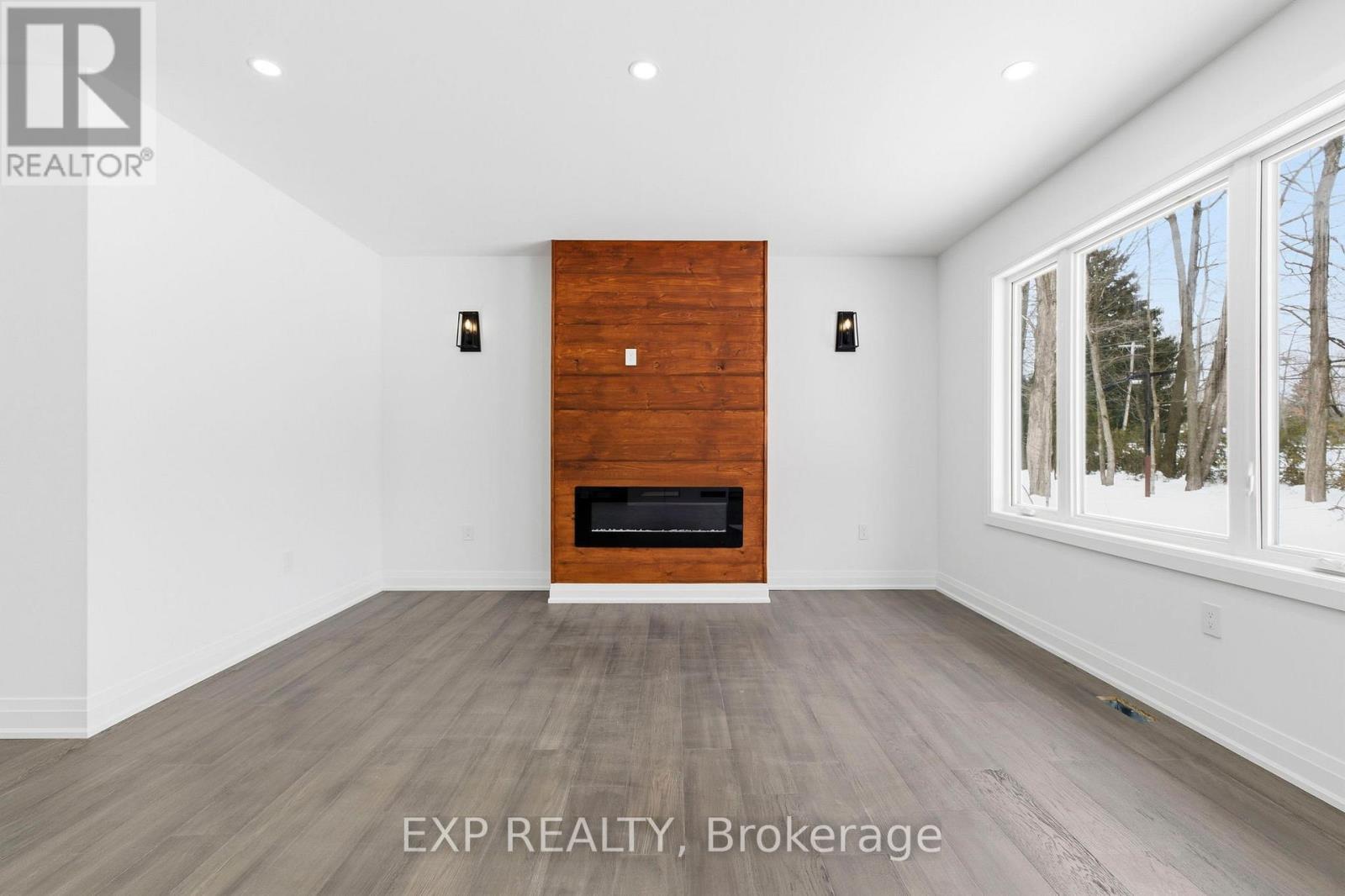 Living room view w/ pine feature wall & fireplace - 49 Beaufort Crescent, Tiny, ON - Indoor With Fireplace