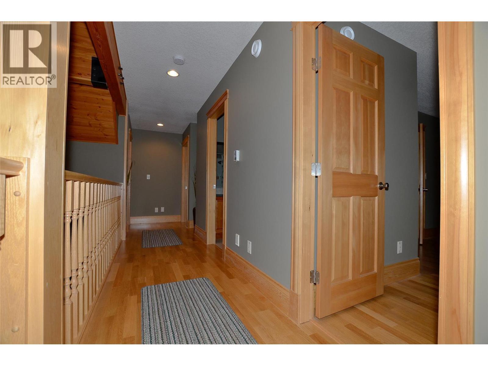 Veranda walkway overlooks the fireplace - 19-3453 Cessna Road, Enderby, BC - Indoor Photo Showing Other Room