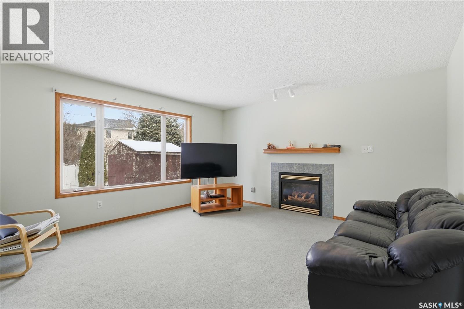 3232 Thames Crescent E, Regina, SK - Indoor Photo Showing Living Room With Fireplace