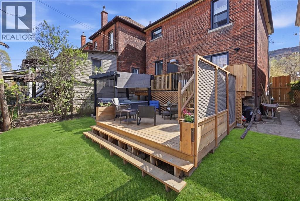 Expansive rear yard featuring a multi-level wood deck, built-in hot tub, and a manicured lawn - 361 Cumberland Avenue, Hamilton, ON - Outdoor With Deck Patio Veranda With Exterior