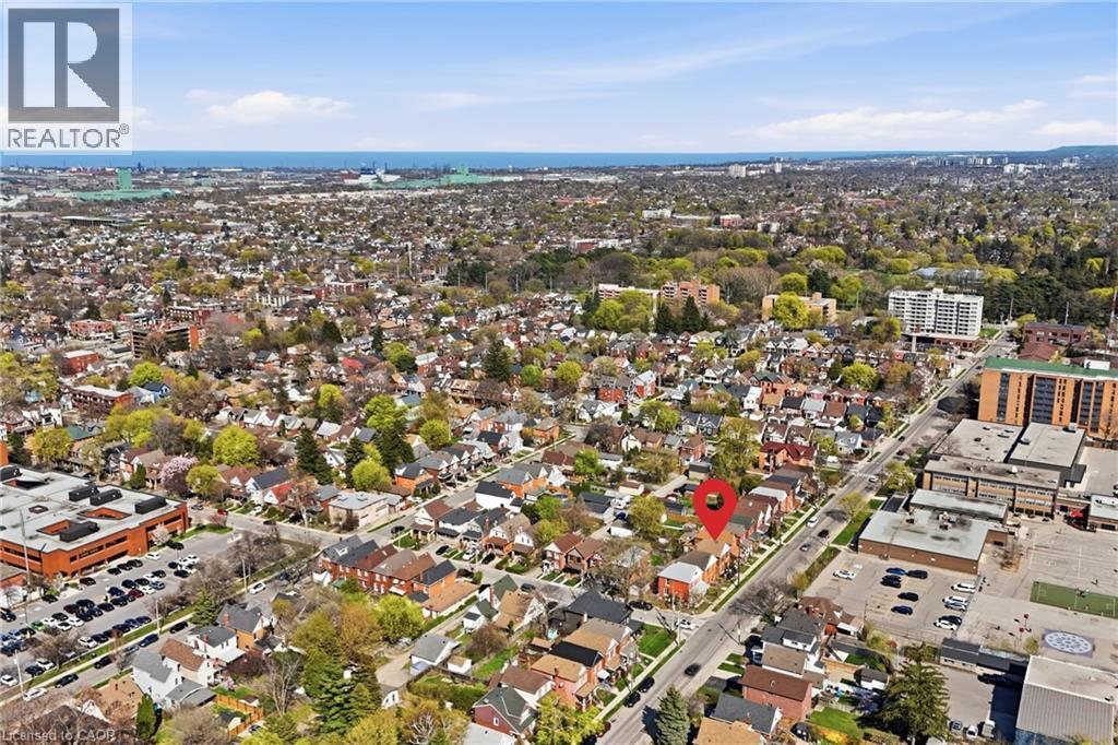 Aerial perspective showcasing a residential neighborhood with varied housing styles, mature trees, and urban infrastructure - 361 Cumberland Avenue, Hamilton, ON - Outdoor With View