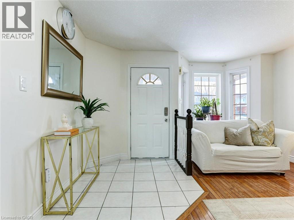 Entryway featuring a white door with an arched window, square-tiled flooring, and a decorative console table - 154 Deerpath Drive, Guelph, ON - Indoor