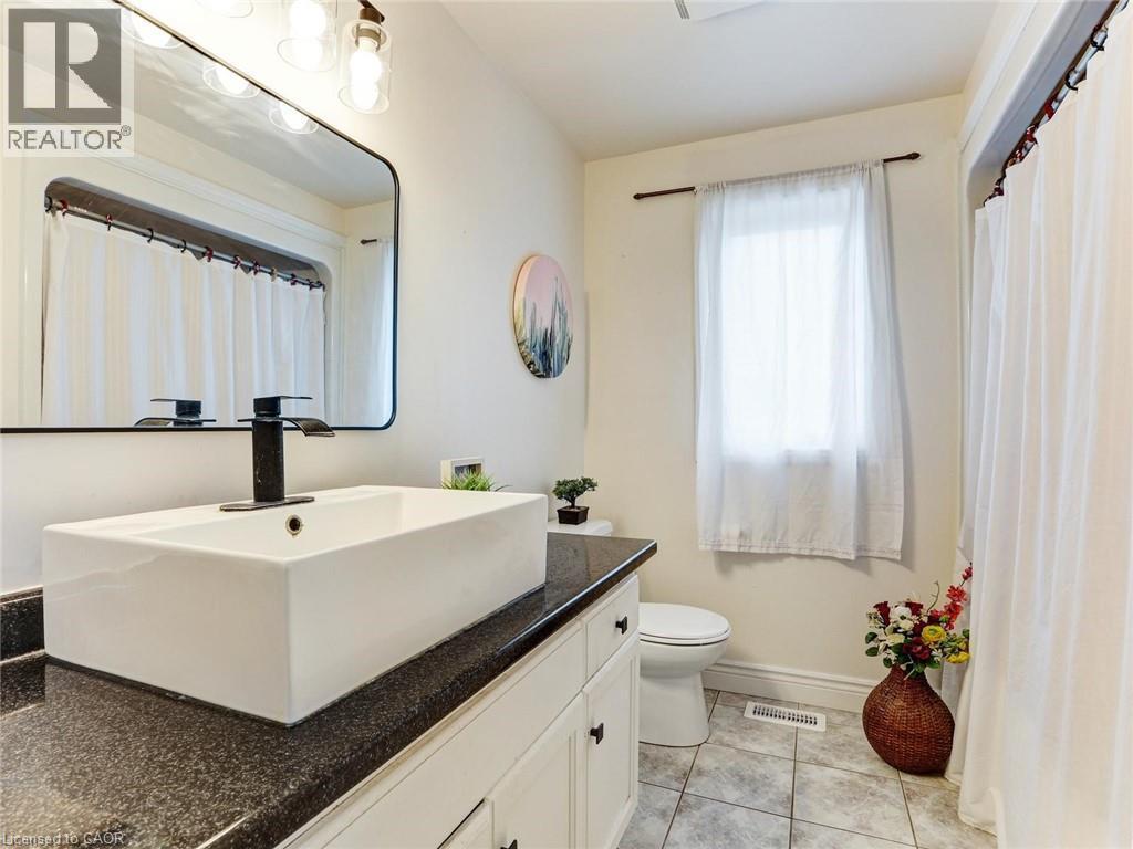Bathroom featuring a rectangular vessel sink with a black faucet, set on a dark countertop - 154 Deerpath Drive, Guelph, ON - Indoor Photo Showing Bathroom