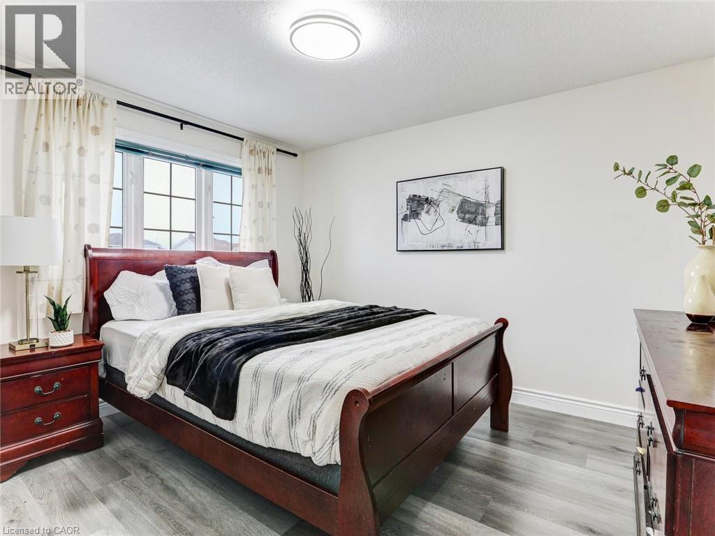 Bright bedroom featuring a multi-pane window, flush-mount ceiling light, and light wood-finish flooring - 154 Deerpath Drive, Guelph, ON - Indoor Photo Showing Bedroom