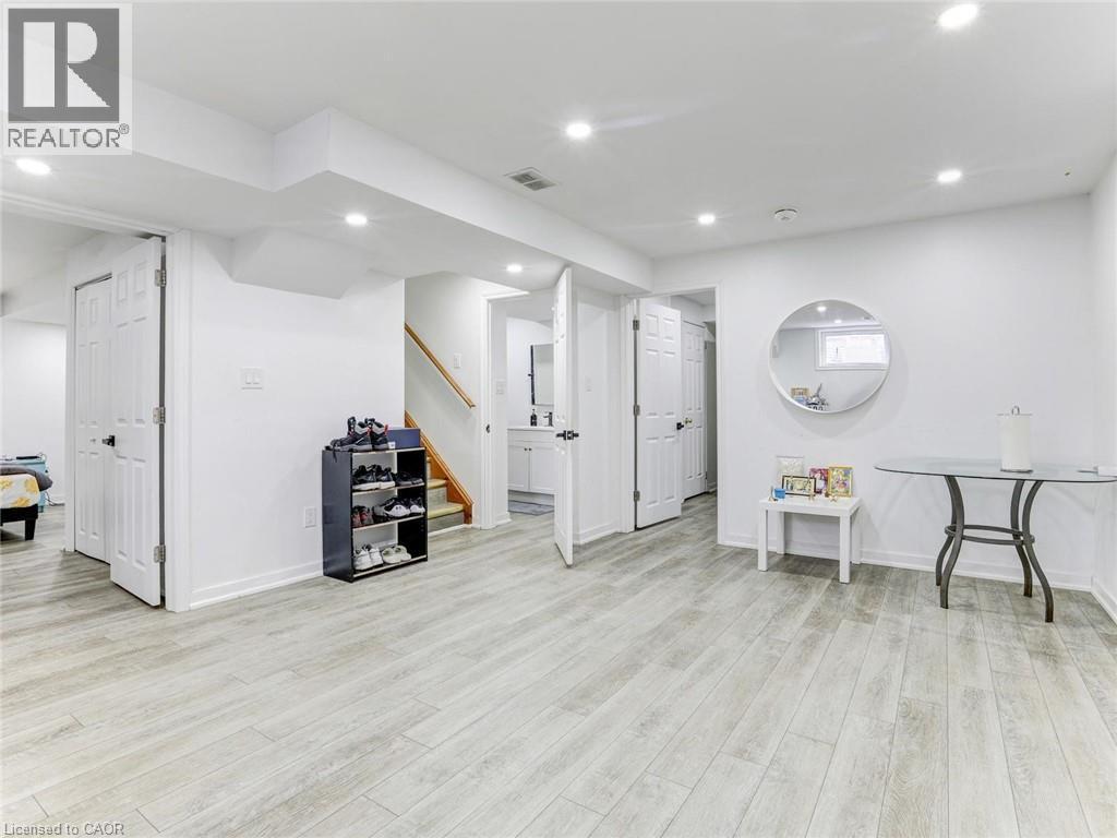 Finished lower level featuring light wood-finish flooring, recessed lighting, white trim, and multiple doorways - 154 Deerpath Drive, Guelph, ON - Indoor Photo Showing Other Room