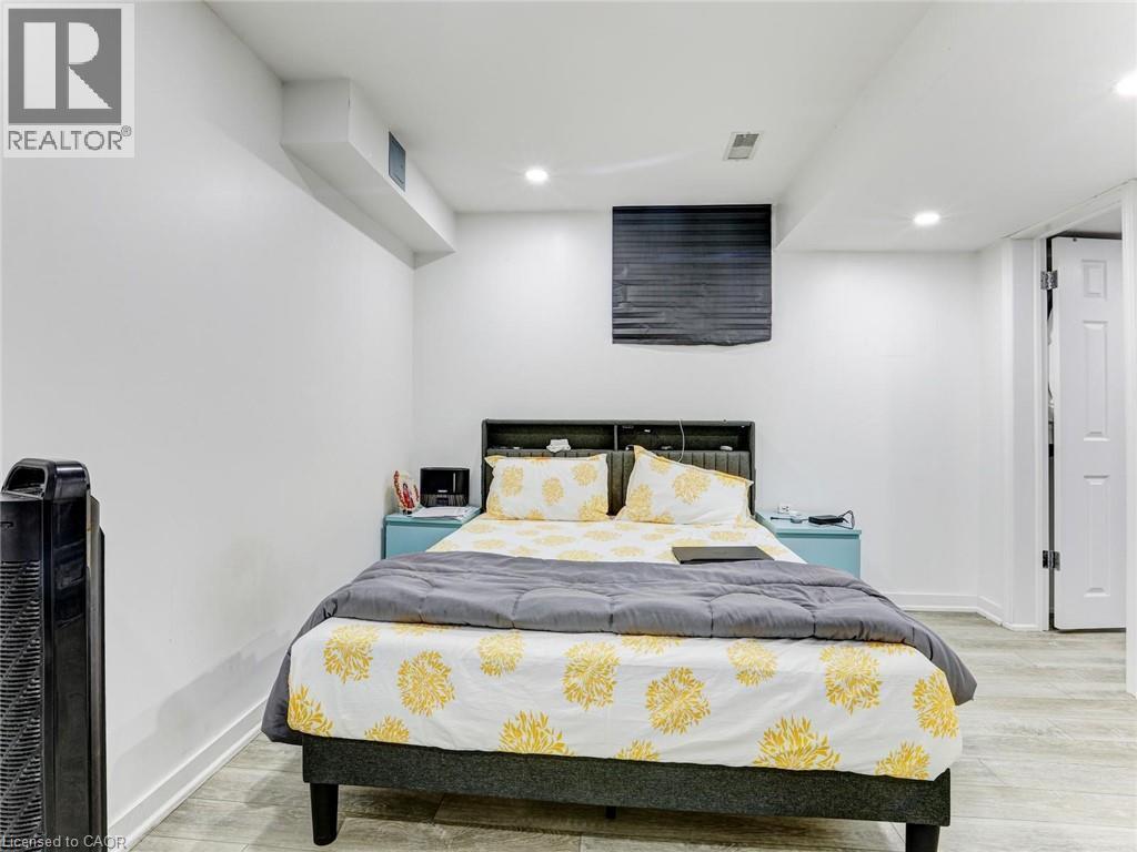 Recessed lighting illuminates this room, featuring light wood-finish flooring and white painted walls - 154 Deerpath Drive, Guelph, ON - Indoor Photo Showing Bedroom