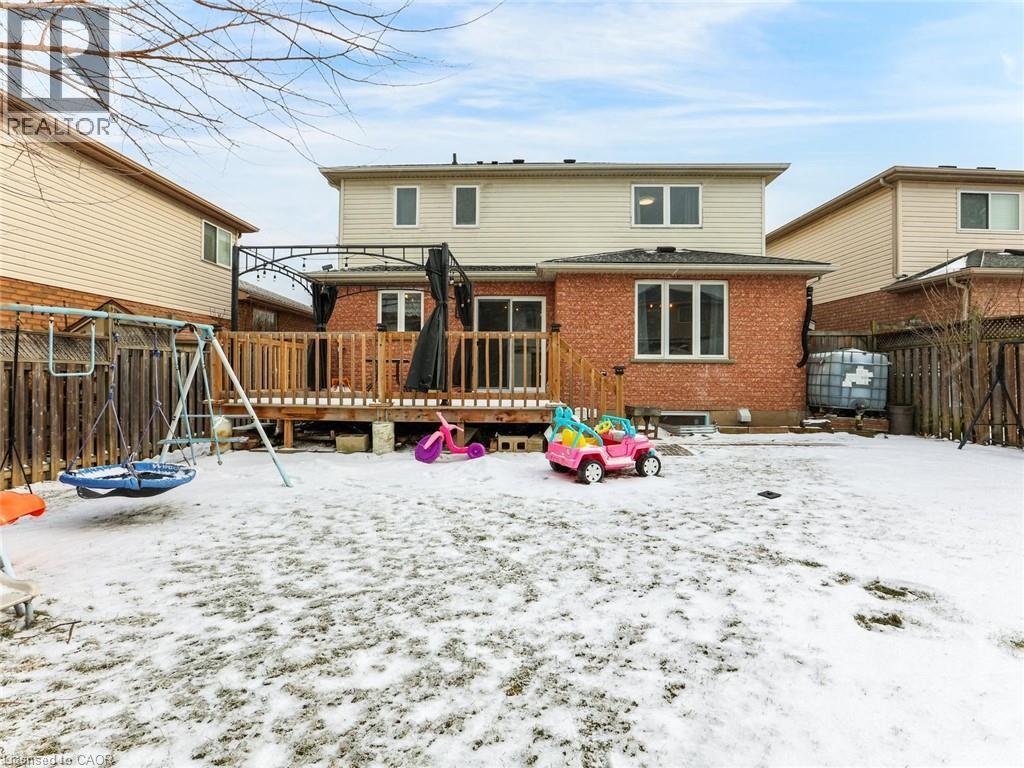 Rear exterior featuring a brick first level, siding second level, and a wooden deck with railing - 154 Deerpath Drive, Guelph, ON - Outdoor With Deck Patio Veranda