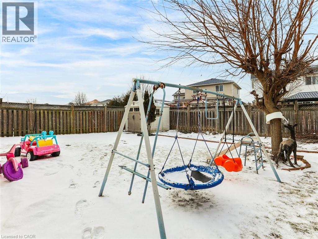 Fenced backyard featuring mature tree and storage shed - 154 Deerpath Drive, Guelph, ON - Outdoor