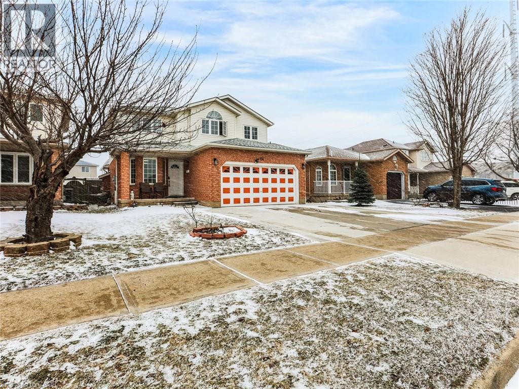 Two-story brick facade residence with an integrated garage featuring a paneled door - 154 Deerpath Drive, Guelph, ON - Outdoor