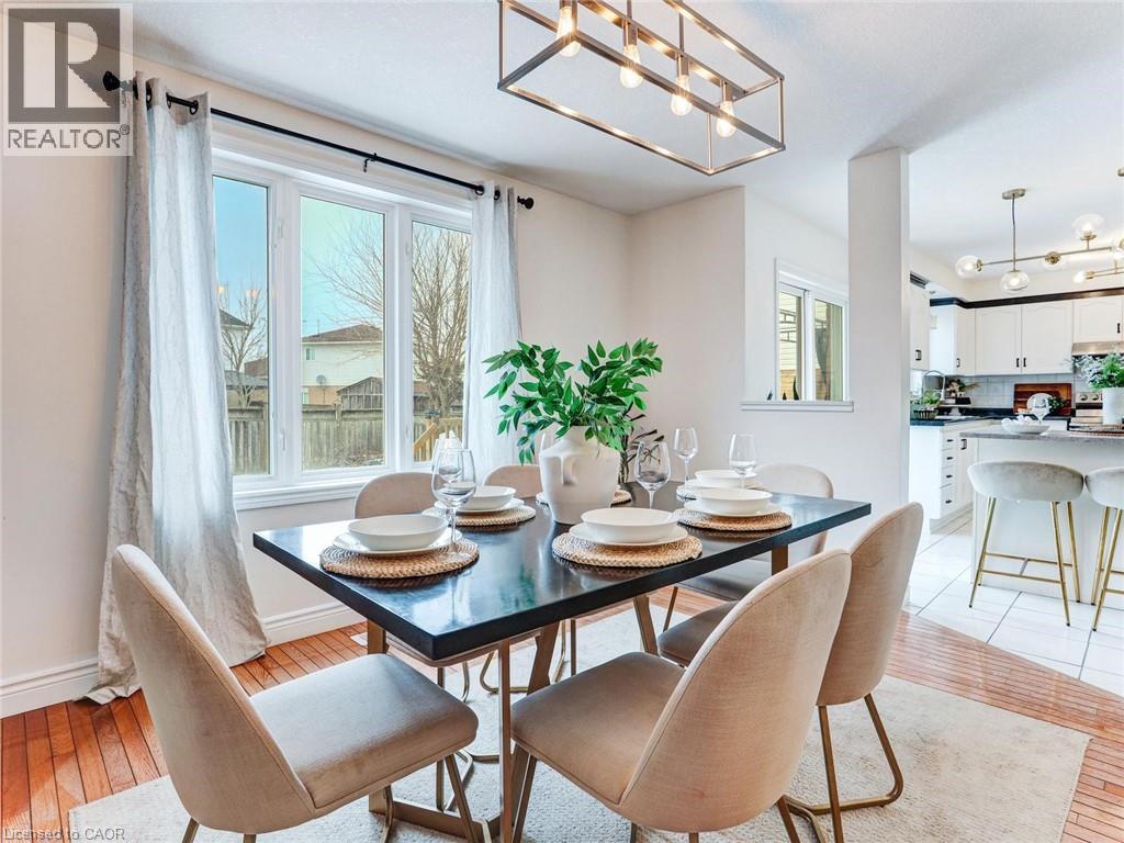 Dining area featuring hardwood flooring, a multi-pane window, and a linear pendant light fixture - 154 Deerpath Drive, Guelph, ON - Indoor Photo Showing Dining Room