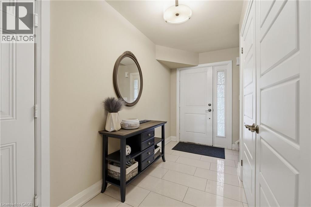 Entryway featuring a white paneled door with sidelight, overhead flush-mount lighting, and light-toned tile flooring - 7 Gibson Place Unit# 26, St. Catharines, ON - Indoor Photo Showing Other Room
