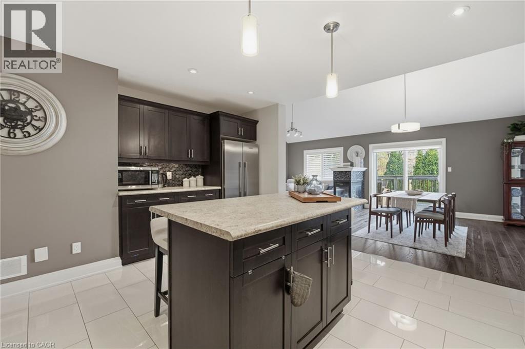 Kitchen island with a light-toned countertop and dark wood-finish cabinetry - 7 Gibson Place Unit# 26, St. Catharines, ON - Indoor Photo Showing Kitchen With Upgraded Kitchen