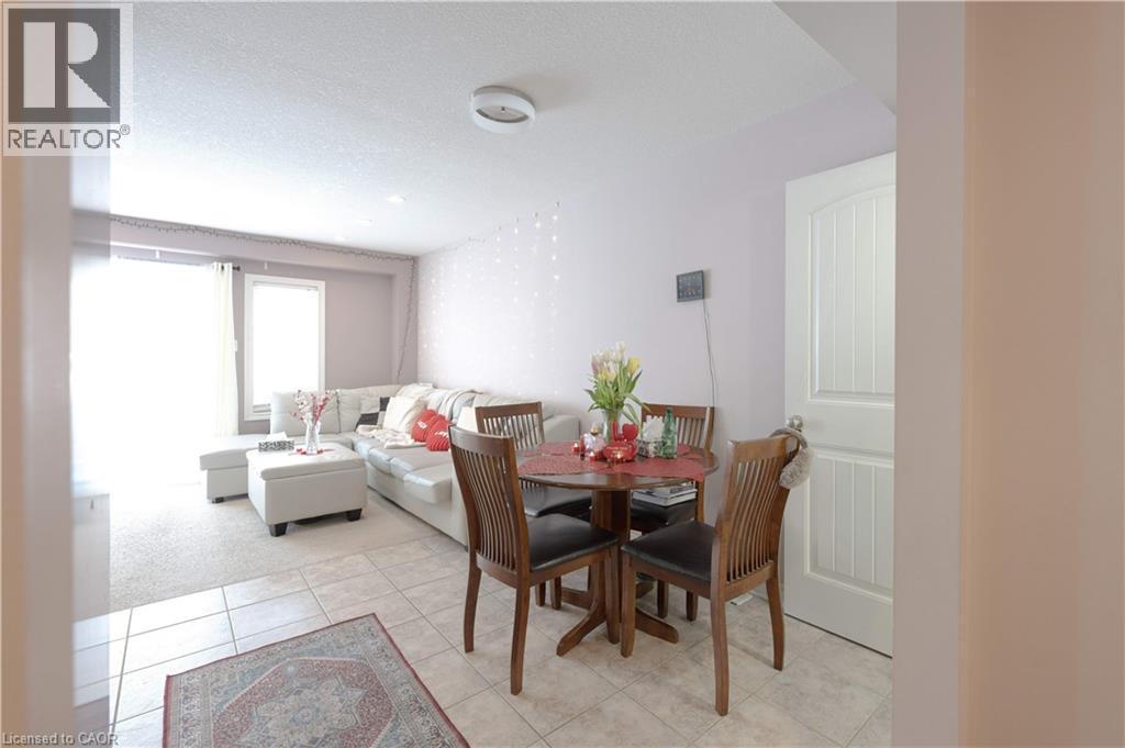 Dining space featuring a textured ceiling, light tile patterned flooring, and light carpet - 535 Margaret Street Unit# 74, Cambridge, ON - Indoor Photo Showing Dining Room