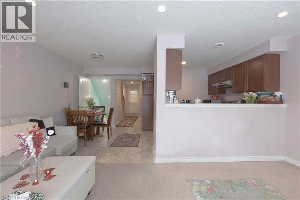 Living room featuring light colored carpet, recessed lighting, light tile patterned floors, and a textured ceiling - 535 Margaret Street Unit# 74, Cambridge, ON - Indoor Photo Showing Living Room
