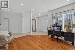 Spacious interior featuring wood-finish flooring, recessed lighting, and a prominent architectural column -
