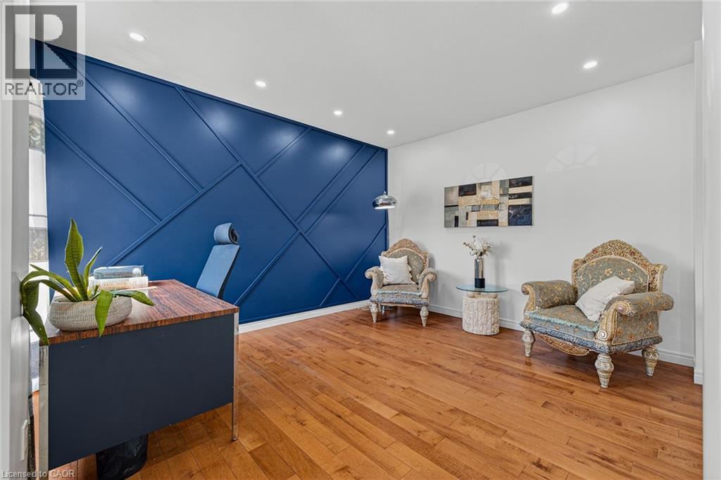 Accent wall featuring geometric paneling, recessed lighting, and wood-finish flooring - 14 Hearthbridge Street, Kitchener, ON - Indoor