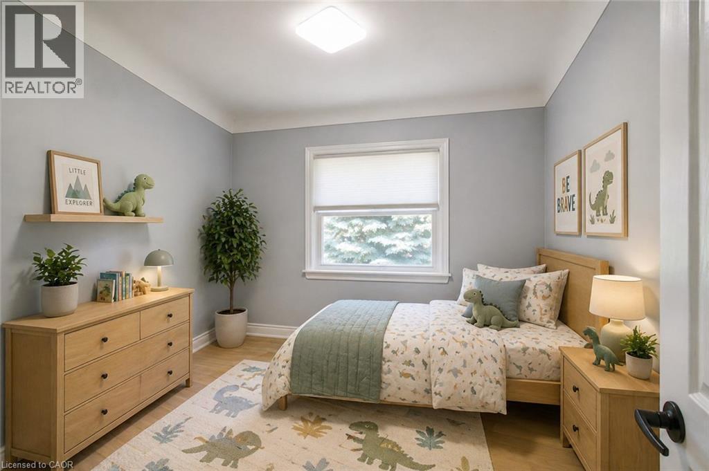 Well-lit room featuring light wood-finish flooring and a single window with a white frame - 31 Brodick Street, Hamilton, ON - Indoor Photo Showing Bedroom