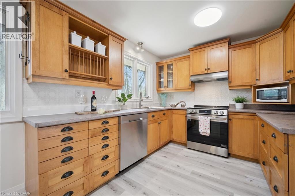 Kitchen featuring wood cabinetry, stainless steel appliances, light-toned countertops, and wood-finish flooring - 27 Silverspring Crescent, Kitchener, ON - Indoor Photo Showing Kitchen