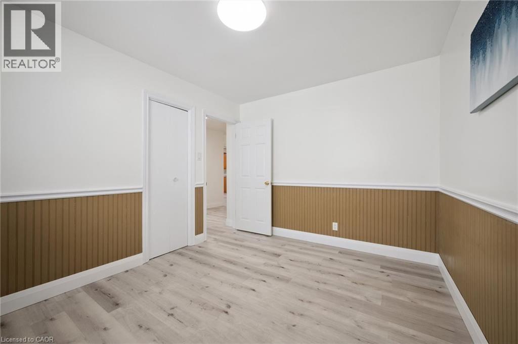 Interior room featuring light wood-finish flooring, white walls, and beadboard wainscoting - 27 Silverspring Crescent, Kitchener, ON - Indoor Photo Showing Other Room